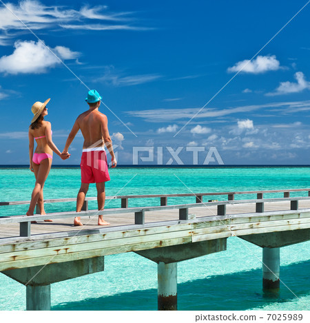 Couple on a beach jetty at Maldives 7025989