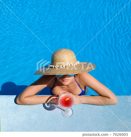 Woman at poolside with cosmopolitan cocktail Woman at poolside with cosmopolitan cocktail 7026003