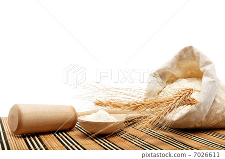 Flour and wheat grain with wooden spoon on a wooden table. Flour and wheat grain with wooden spoon on a wooden table. 7026611