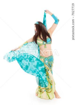 A young lady dancer dancing with a sexy costume shaking a silk veil violently 7027719
