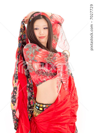 一位年輕的女士與她的裙子跳舞激情的肚皮舞 一位年輕的女士與她的裙子跳舞激情的肚皮舞 7027729