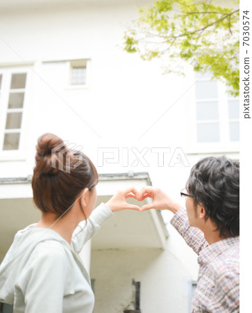 A couple making hearts in the garden A couple making hearts in the garden 7030574