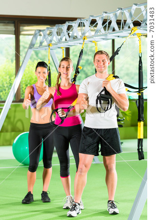 People in sport gym on suspension trainer 7031483