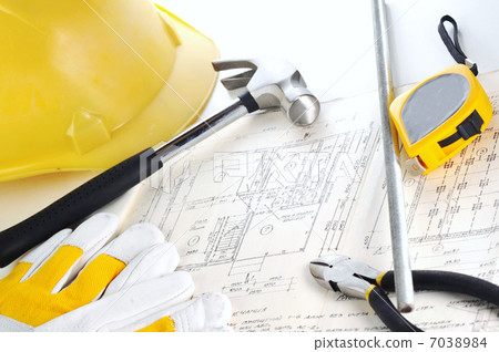 Yellow hardhat on drawings 7038984