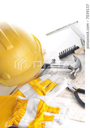 Yellow hardhat on drawings 7039137