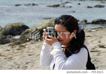 A woman taking with a rangefinder camera A woman taking with a rangefinder camera 7051021