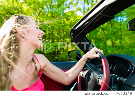 Young woman with cabriolet in summer on day trip 7053549