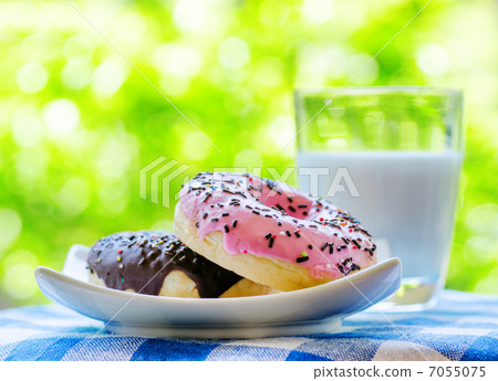 Fresh donuts and glass of milk on nature background 7055075