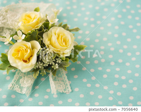 A light blue polka dots cloth and a yellow rose bull 7056640
