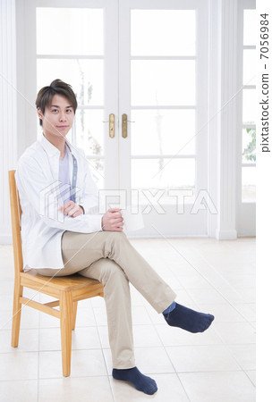 A young man sitting in a chair and relaxing A young man sitting in a chair and relaxing 7056984
