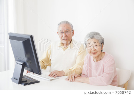A couple looking at a personal computer A couple looking at a personal computer 7058742