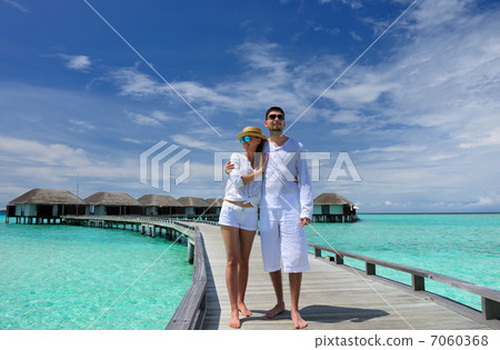 Couple on a beach jetty at Maldives Couple on a beach jetty at Maldives 7060368