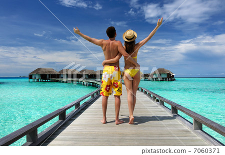 Couple on a beach jetty at Maldives Couple on a beach jetty at Maldives 7060371