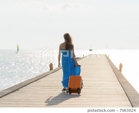Young woman walking on wooden pier 7063024