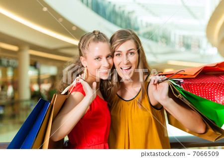Two women shopping with bags in mall 7066509