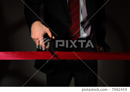 Businessman with scissors cuting a red ribbon Businessman with scissors cuting a red ribbon 7092459