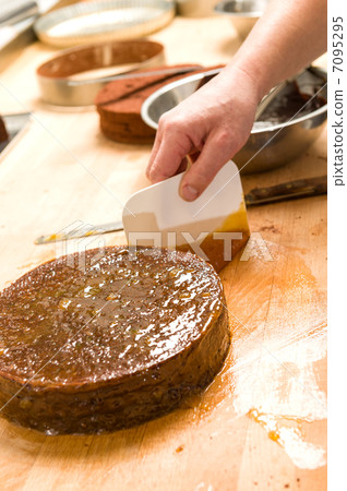 Male chef decorating chocolate cake in kitchen 7095295
