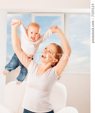 Mother and baby are playing active games, do gymnastics and laug 7103123