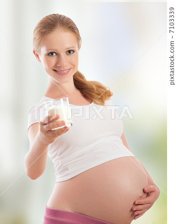 beautiful young pregnant woman and glass of milk 7103339