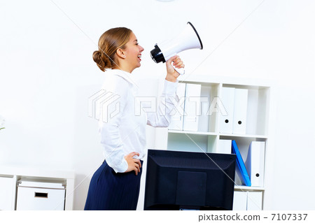 Young woman with megaphone in office 7107337