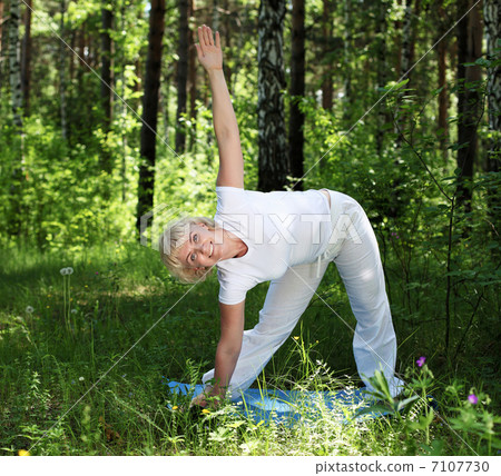 An elderly woman practices yoga An elderly woman practices yoga 7107730