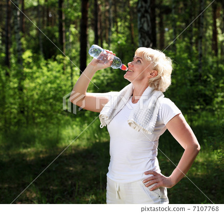 elderly woman after exercising in the forest elderly woman after exercising in the forest 7107768