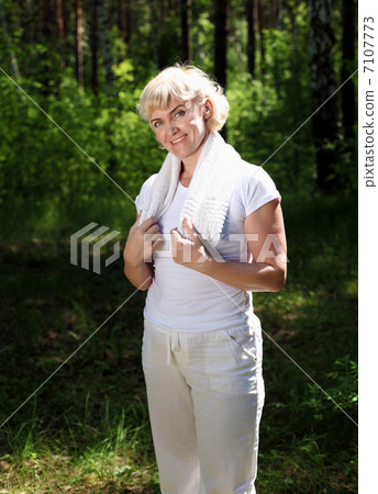 Portrait of an elderly woman in sportswear with a towel 7107773