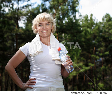 elderly woman after exercising in the forest elderly woman after exercising in the forest 7107828