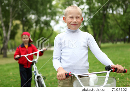 Boy on a bicycle in the green park Boy on a bicycle in the green park 7108102