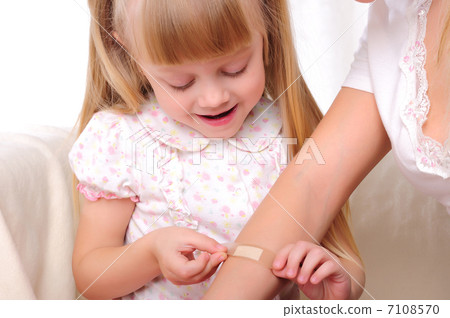 little girl puts a plaster 7108570