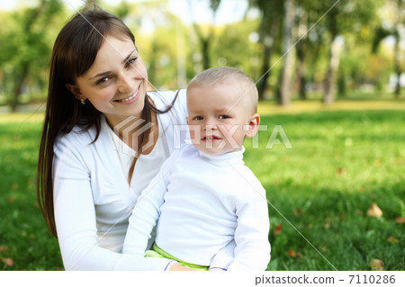 Young mother with her son in summer park Young mother with her son in summer park 7110286