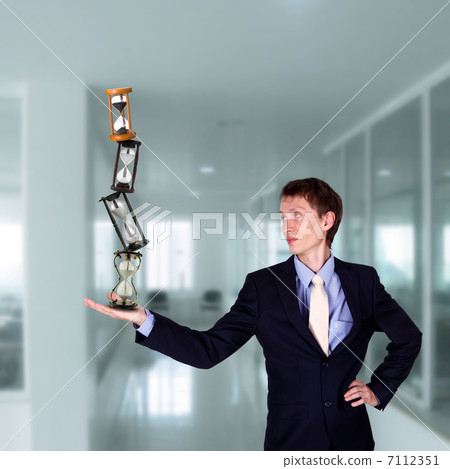 businessman in office holding clock pyramid businessman in office holding clock pyramid 7112351