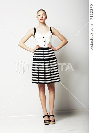 Trendy Woman in Stripped Skirt and T-Shirt standing. Urban Clothing Collection Trendy Woman in Stripped Skirt and T-Shirt standing. Urban Clothing Collection 7112870