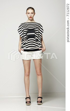 Full Length of Trendy Woman in Shorts and Grey Striped Shirt. Casual Modern Collection Full Length of Trendy Woman in Shorts and Grey Striped Shirt. Casual Modern Collection 7112872