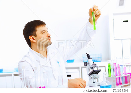 Young male scientist working in laboratory 7119864