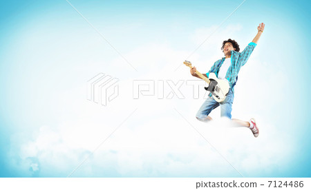young man playing on electro guitar and jumping young man playing on electro guitar and jumping 7124486