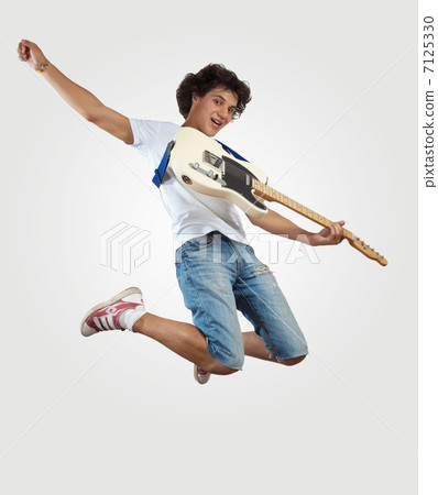 young man playing on electro guitar and jumping 7125330