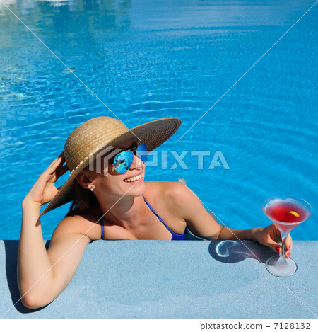 Woman at poolside with cosmopolitan cocktail 7128132