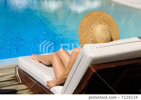 Woman relaxing at the poolside Woman relaxing at the poolside 7128134
