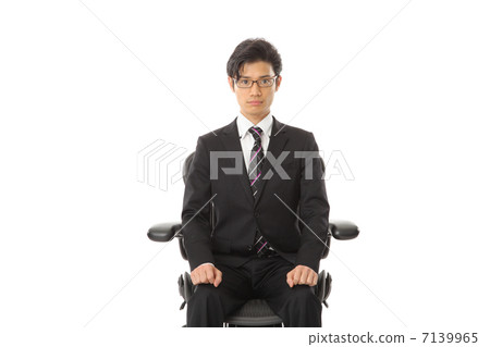 A businessman sitting in a chair A businessman sitting in a chair 7139965