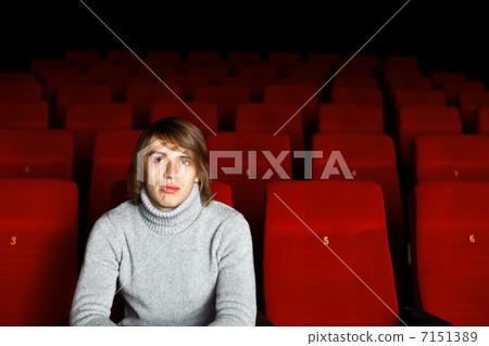 Young man in cinema watching movie Young man in cinema watching movie 7151389