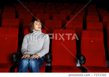 Young man in cinema watching movie Young man in cinema watching movie 7151391