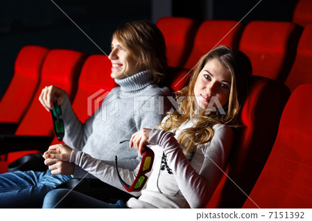 Young couple in cinema watching movie Young couple in cinema watching movie 7151392