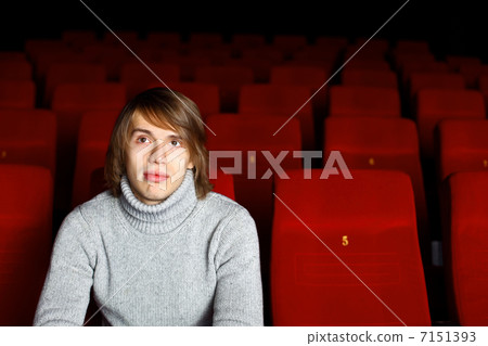 Young man in cinema watching movie Young man in cinema watching movie 7151393