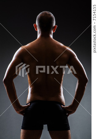 Muscular man in dark studio Muscular man in dark studio 7154155