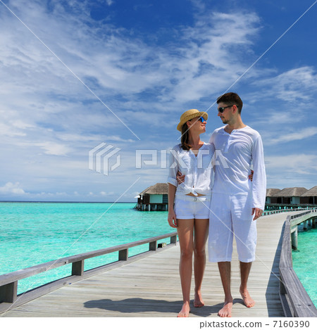 Couple on a beach jetty at Maldives 7160390