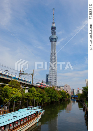 Limited express train coming and going with Tokyo sky tree spreading blue sky 7168838