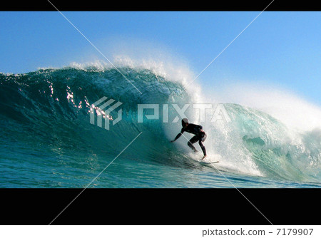 進入藍色海波浪沖浪者的管的衝浪者乘坐大波浪管 7179907