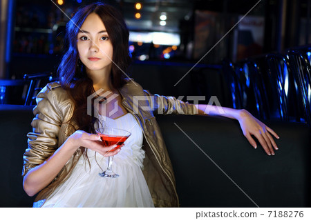Attractive woman in night club with a drink Attractive woman in night club with a drink 7188276