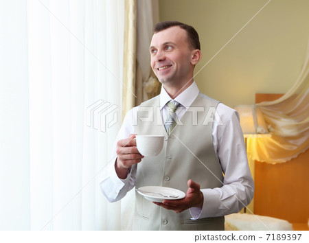 young businessman near the window drinking tea 7189397